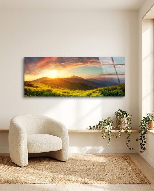 Golden sunset green hills panoramic glass wall art above a white boucle chair and trailing plants