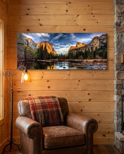 Granite cliffs river valley panoramic glass wall art on a knotty pine wall above a leather armchair
