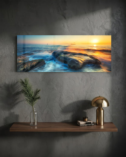 Mossy rocks sunrise sea glass wall art above a floating walnut shelf with a brass lamp