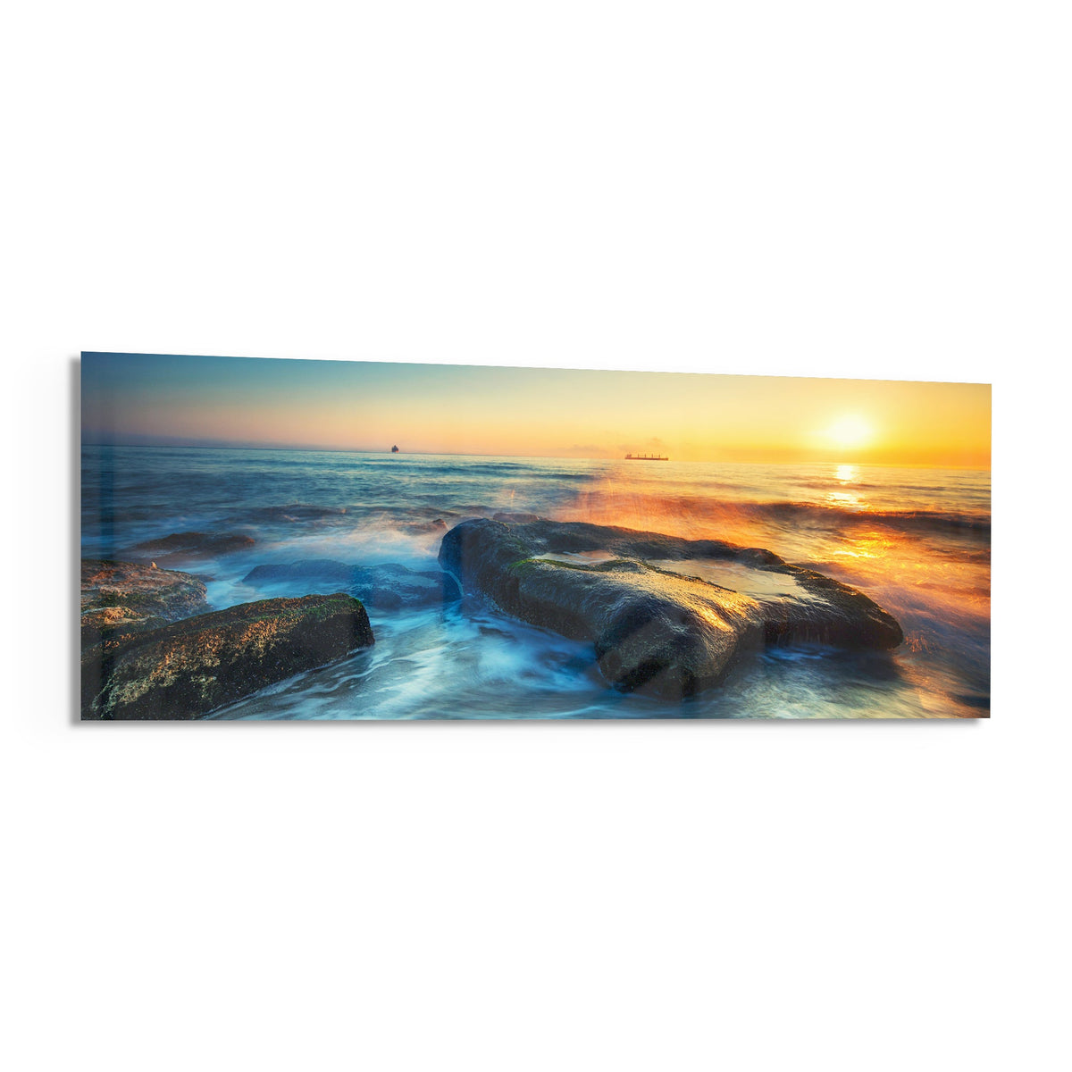 Mossy rocks sunrise sea panoramic glass print angled on a white background