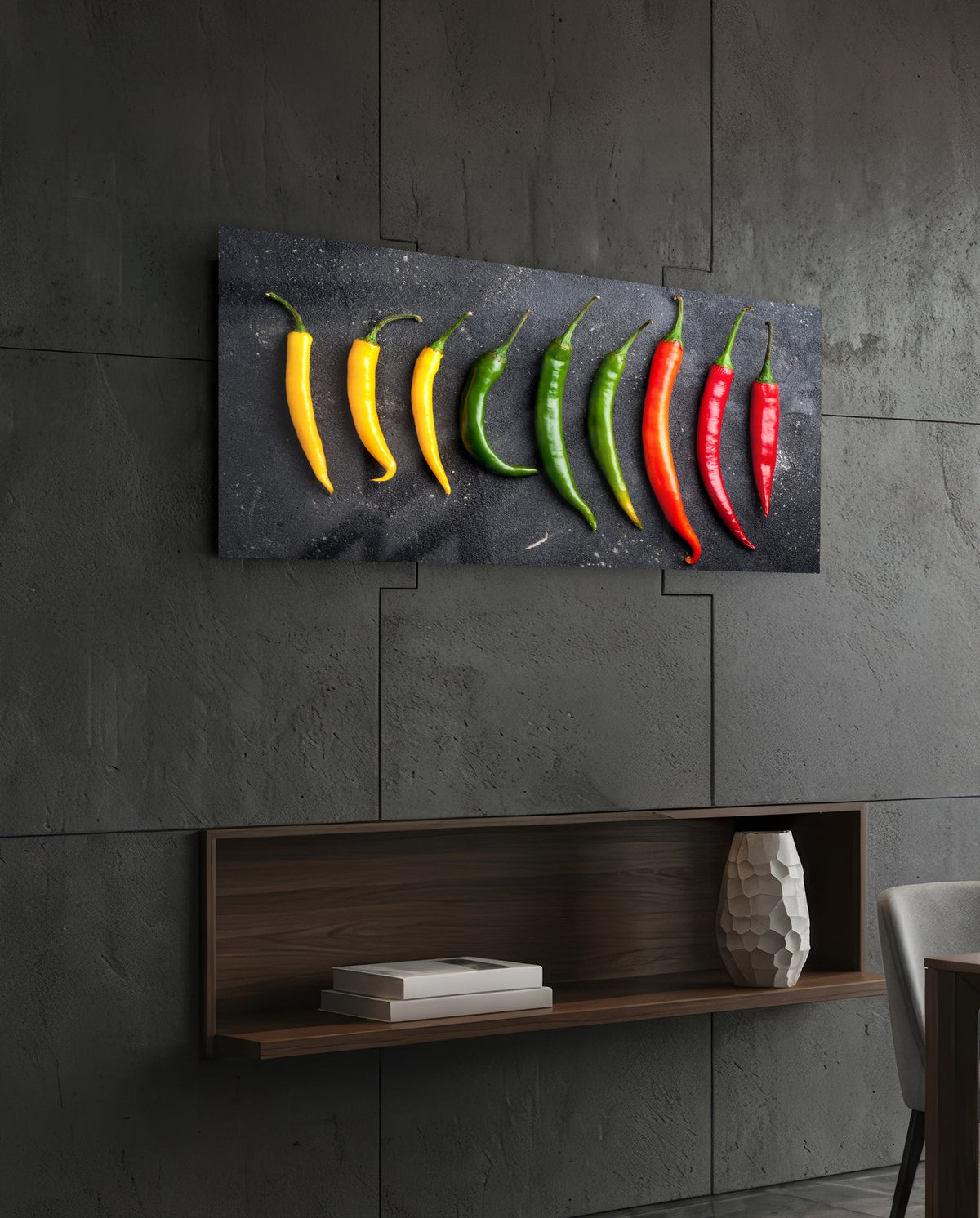 Chili peppers on black slate glass wall art on a dark tiled wall above a recessed walnut shelf with a vase