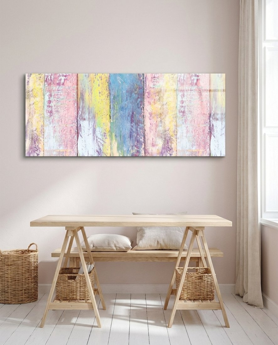Pastel painted wood planks glass wall art above a light wooden trestle desk with woven baskets