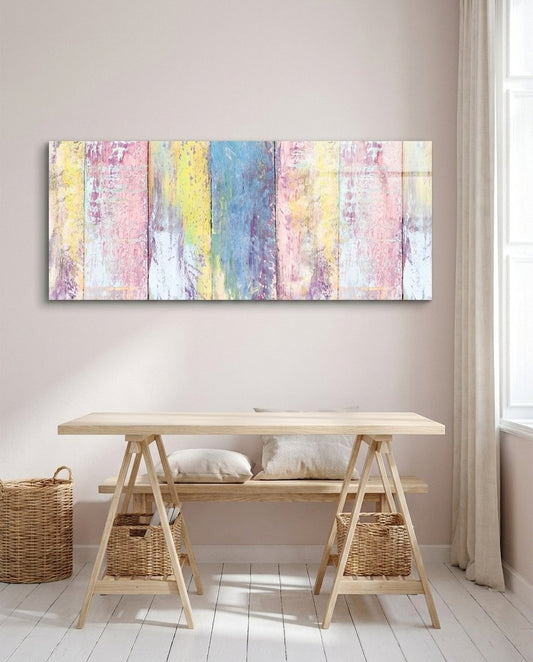 Pastel painted wood planks glass wall art above a light wooden trestle desk with woven baskets