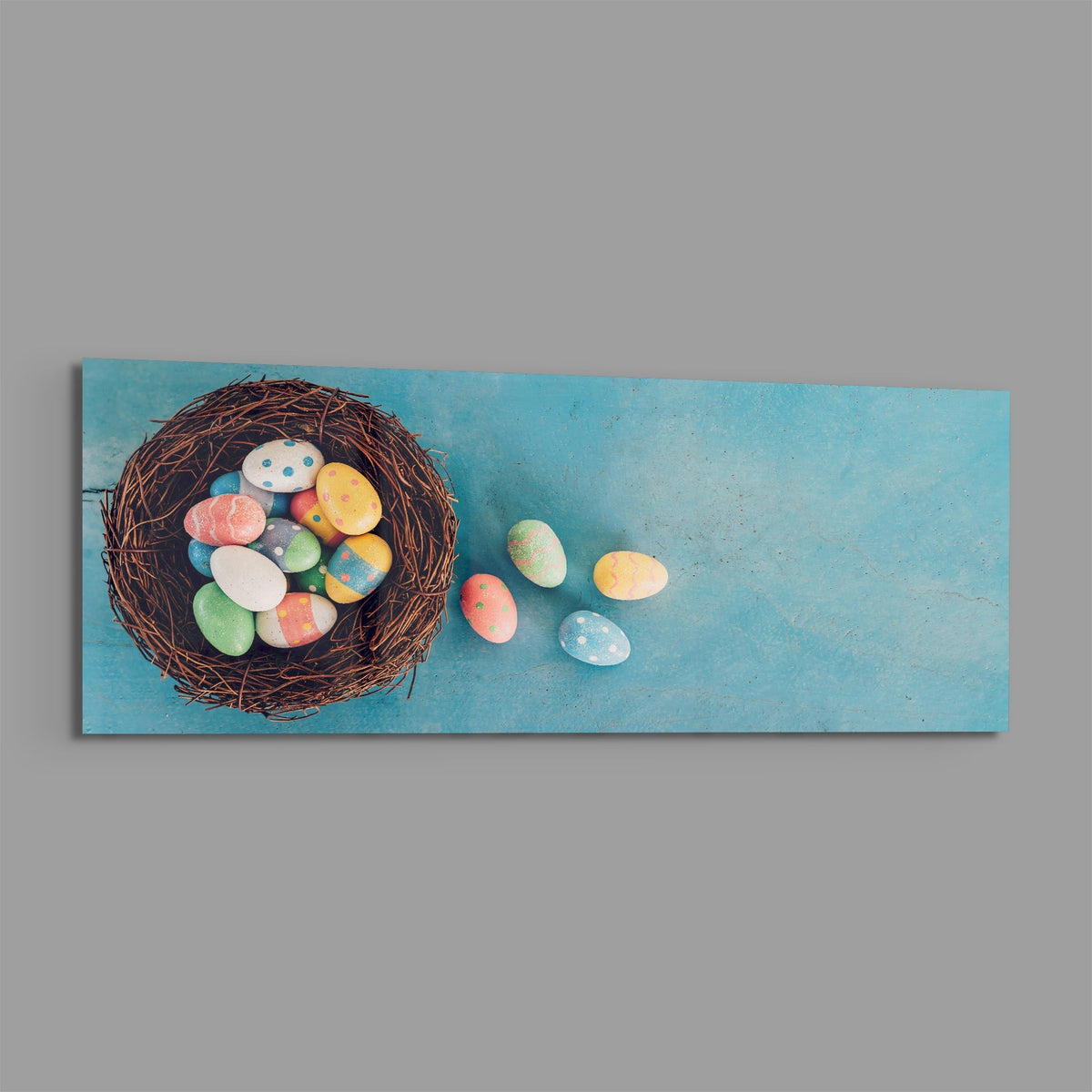 Easter eggs in a nest panoramic glass piece shown on a plain gray background