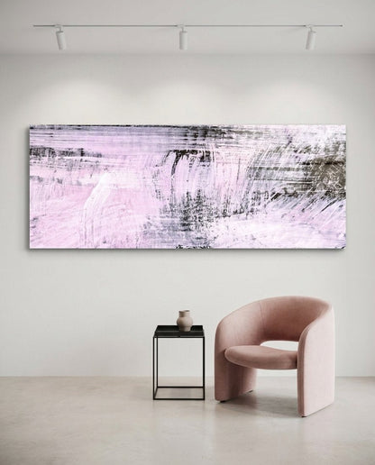 Blush pink and charcoal brushstroke glass wall art above a pink armchair and a small black side table