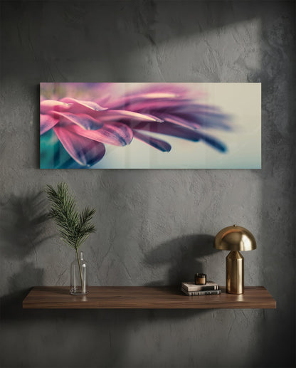 Pink flower petal macro glass wall art on a charcoal wall above a floating shelf with a brass lamp and greenery