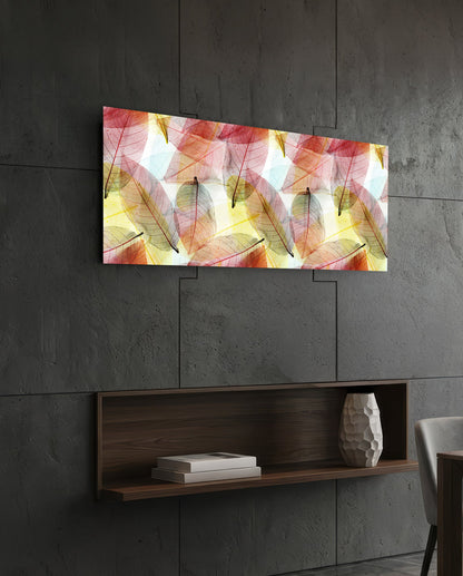 Pink and gold skeleton leaves glass wall art on a dark slate wall above a walnut floating shelf