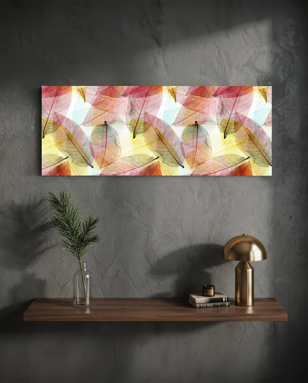 Pink and gold skeleton leaves glass wall art above a floating shelf with a brass lamp and a plant in a vase