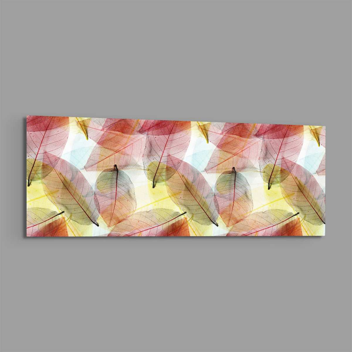 Pink and gold skeleton leaves panoramic glass wall art shown on a plain gray background