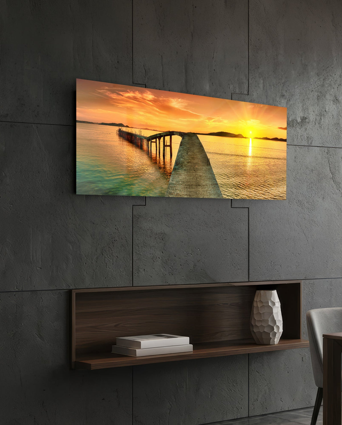 Golden sunset curved pier glass wall art above a dark wood wall shelf on a charcoal paneled wall