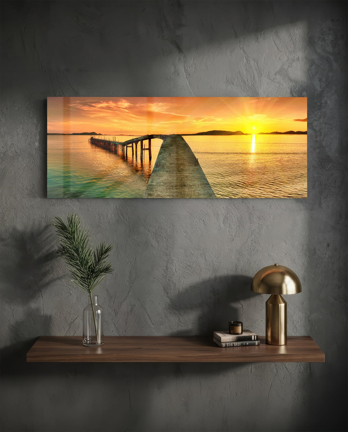 Golden sunset curved pier glass wall art above a floating walnut shelf with a brass lamp