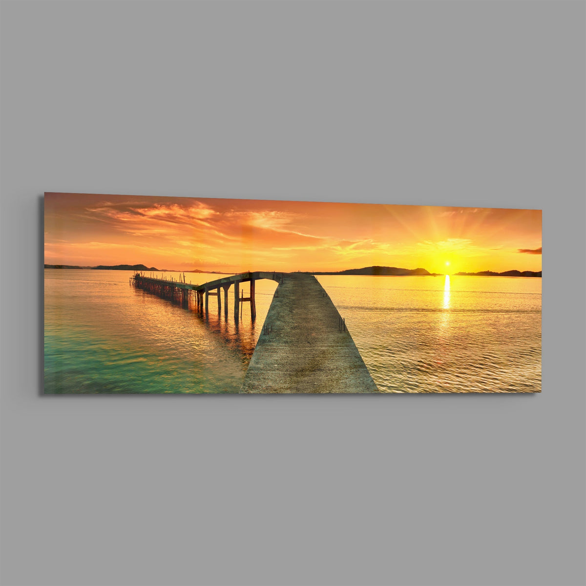 Golden sunset curved pier panoramic glass print angled on a gray background