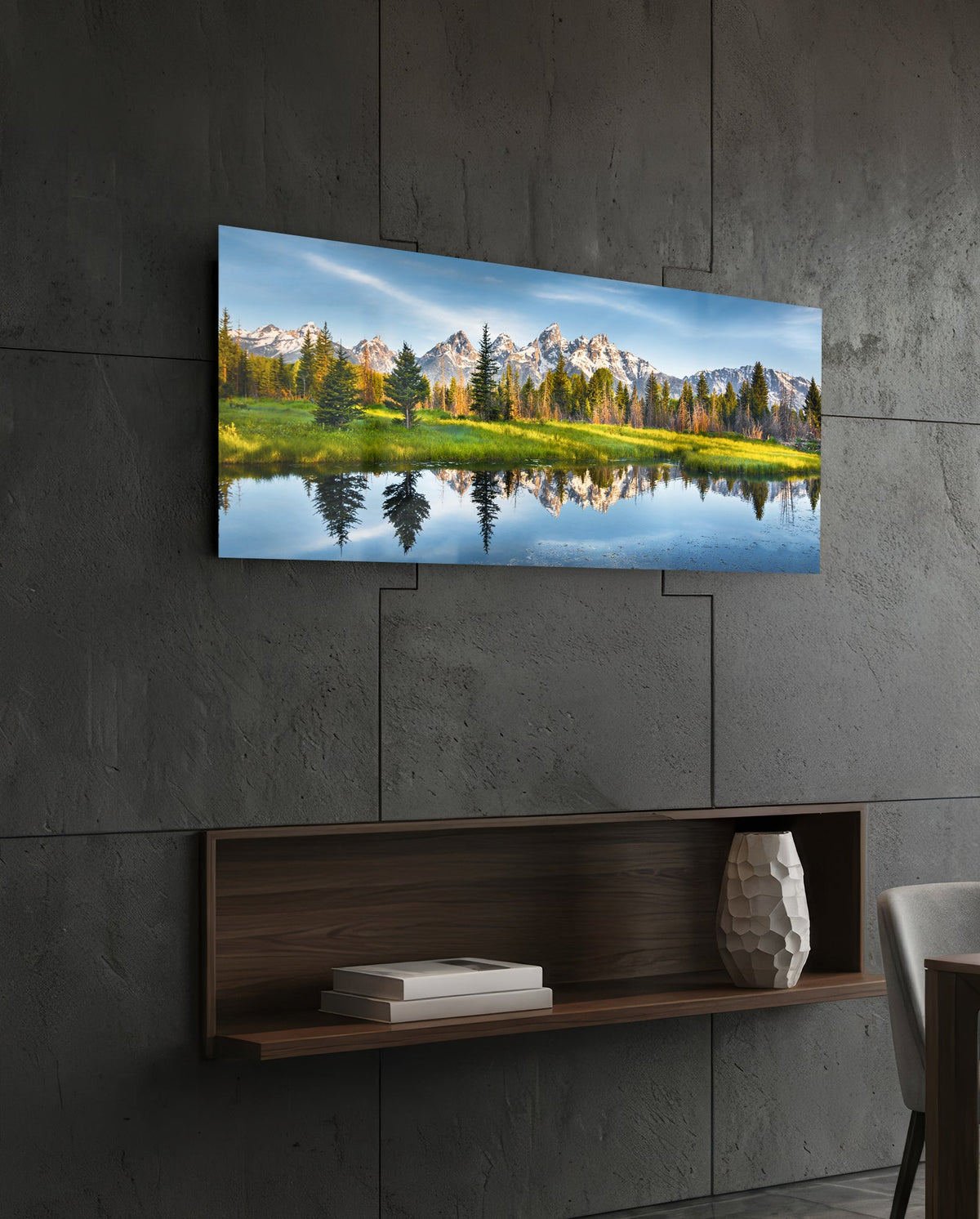 Mountain lake reflection glass wall art on a dark tiled wall above a recessed walnut shelf with a vase