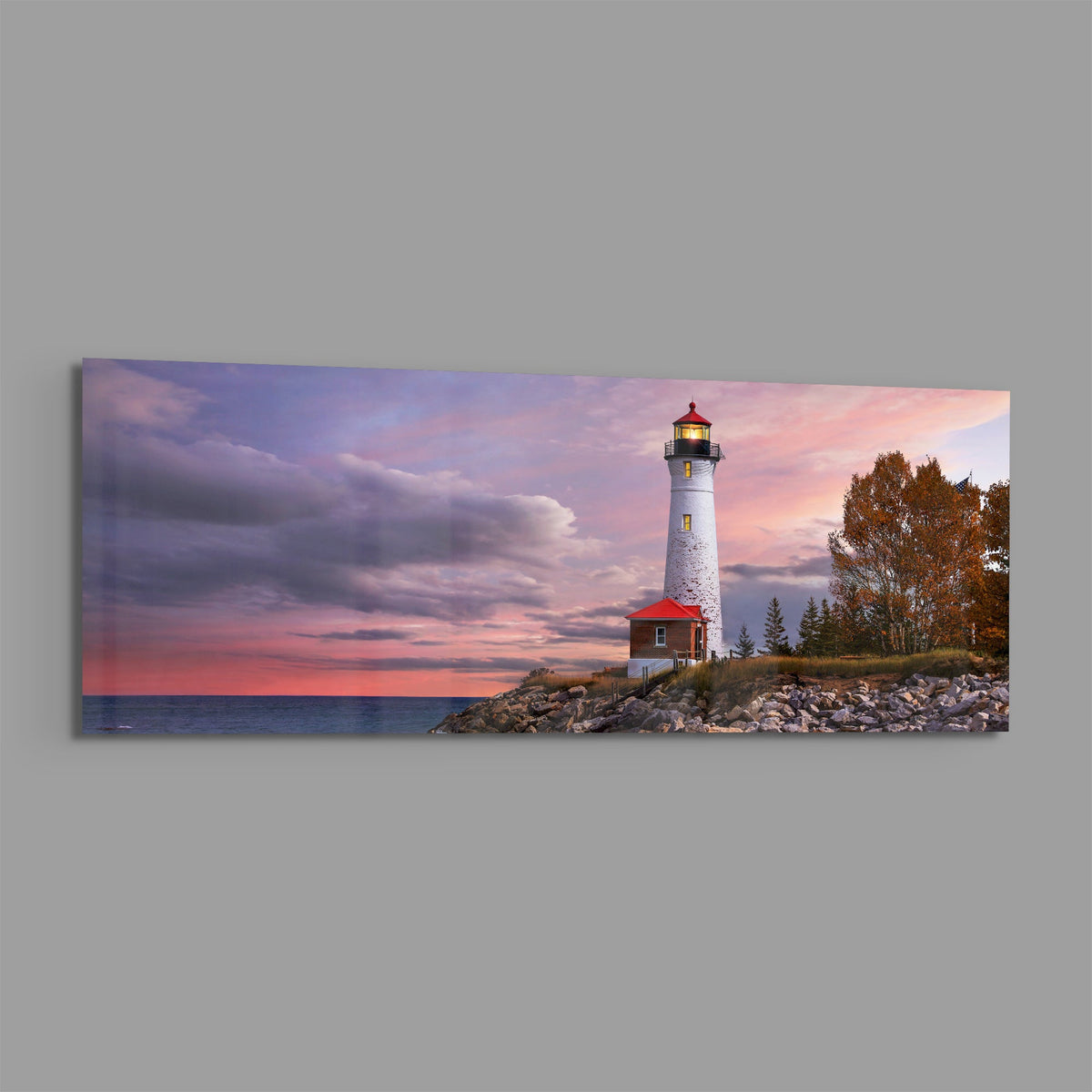 Lighthouse at dusk panoramic glass print angled on a gray background
