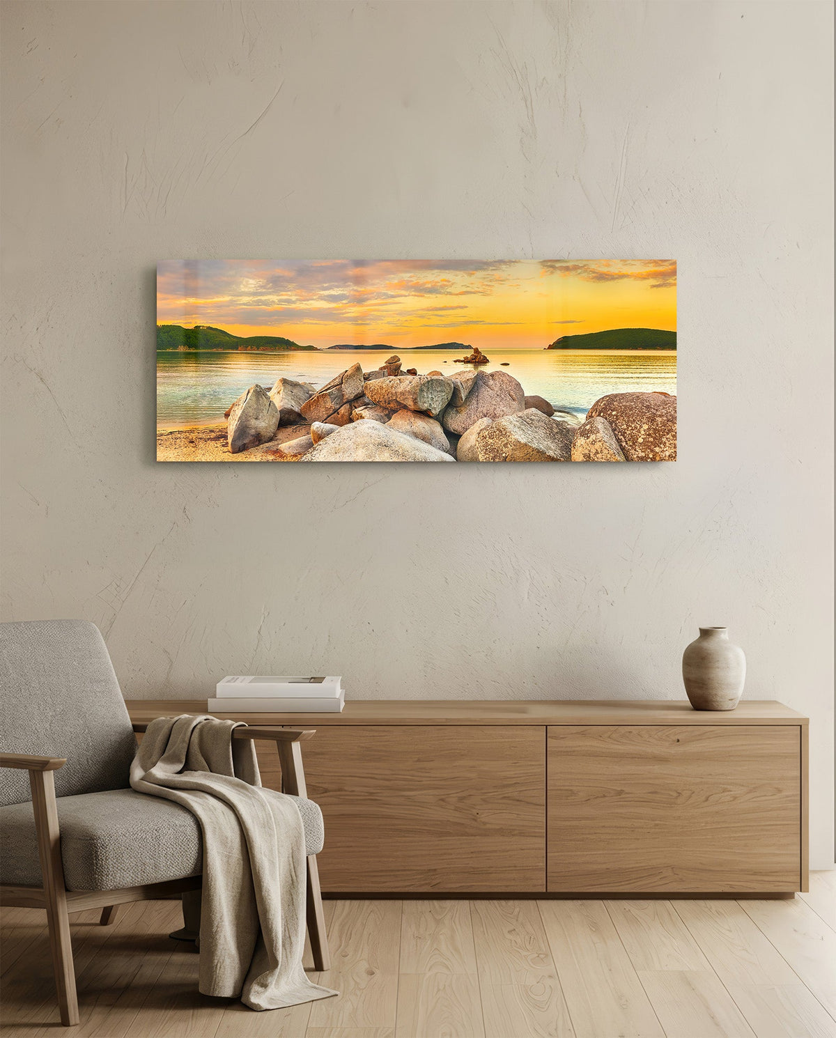 Golden sunset boulder bay glass wall art above a light oak sideboard beside a cream armchair