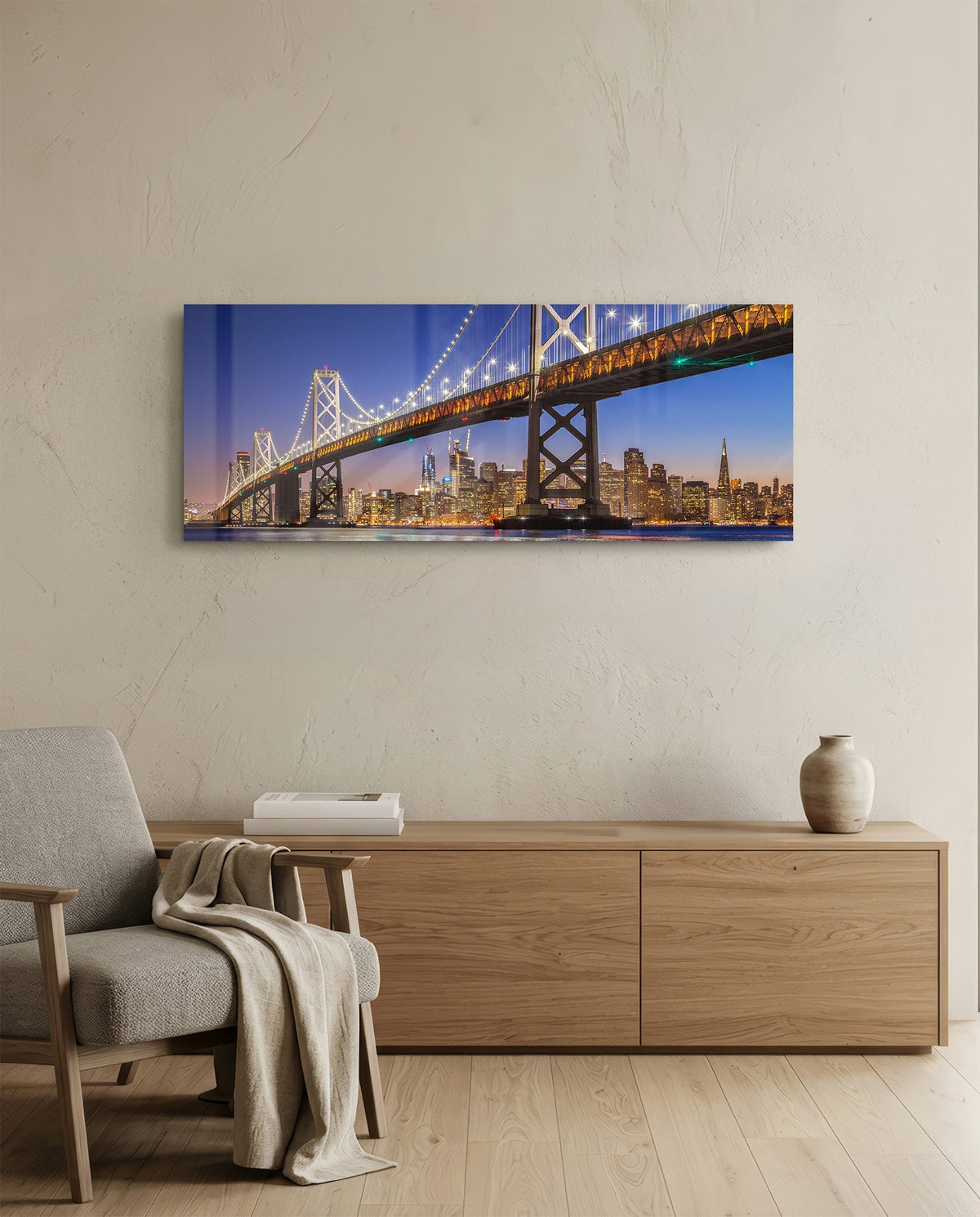 San Francisco Bay Bridge panoramic glass wall art above a light wood sideboard and beige armchair