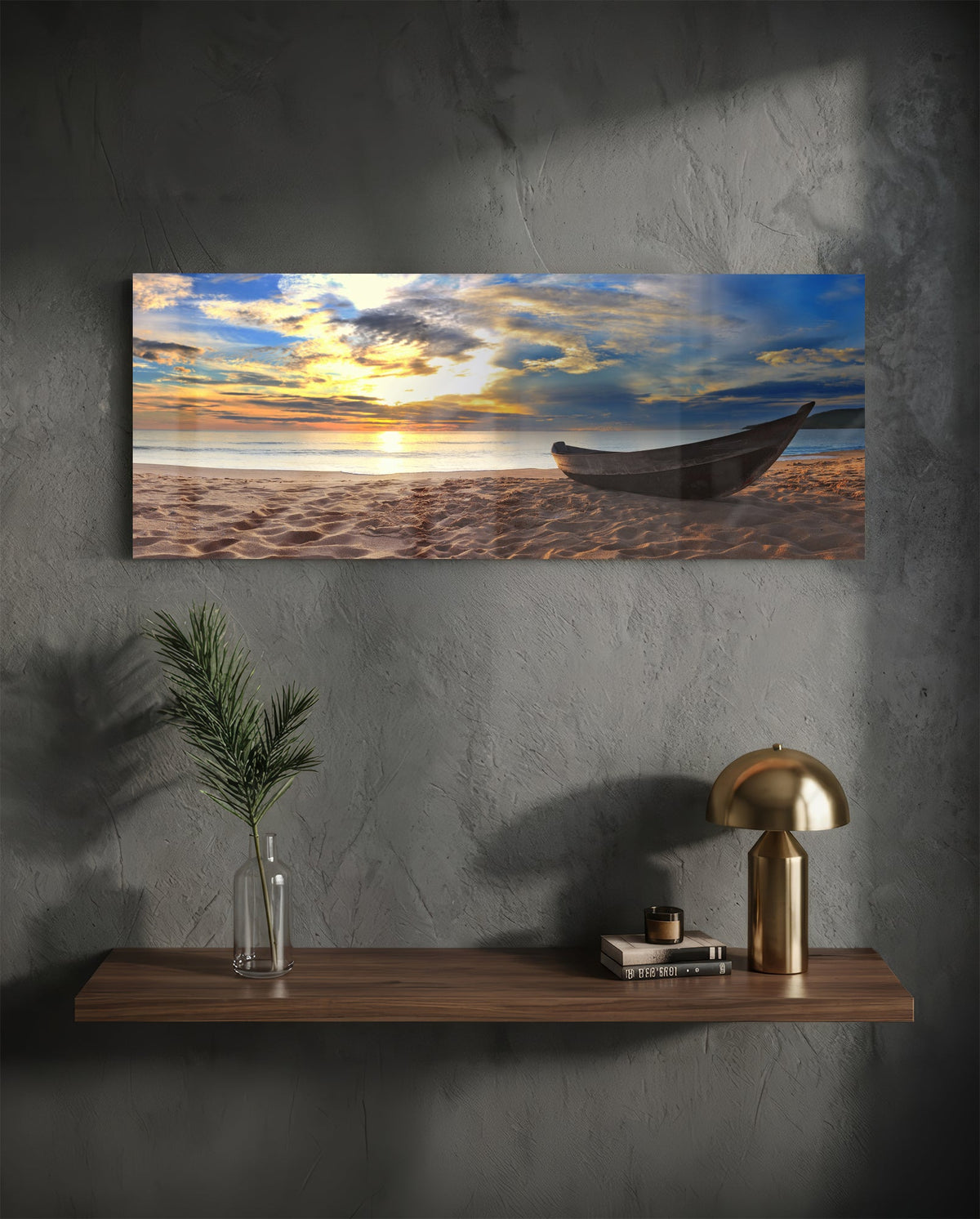 Wooden boat on a sandy beach at sunset glass wall art above a floating walnut shelf with a brass lamp