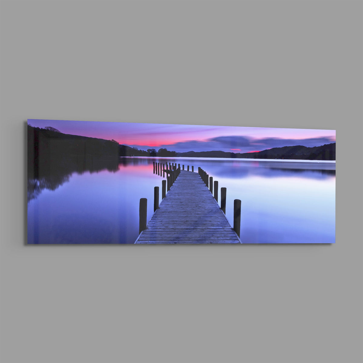 Purple twilight lake jetty panoramic glass print angled on a gray background