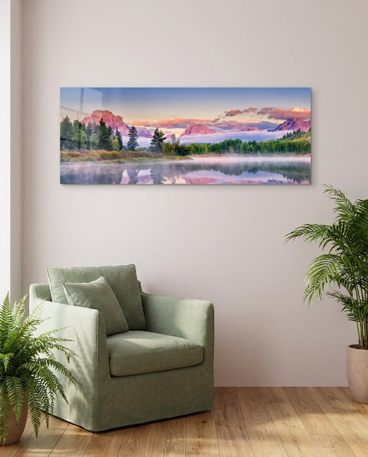 Pink dawn mountain lake panoramic glass wall art above a sage green armchair beside ferns