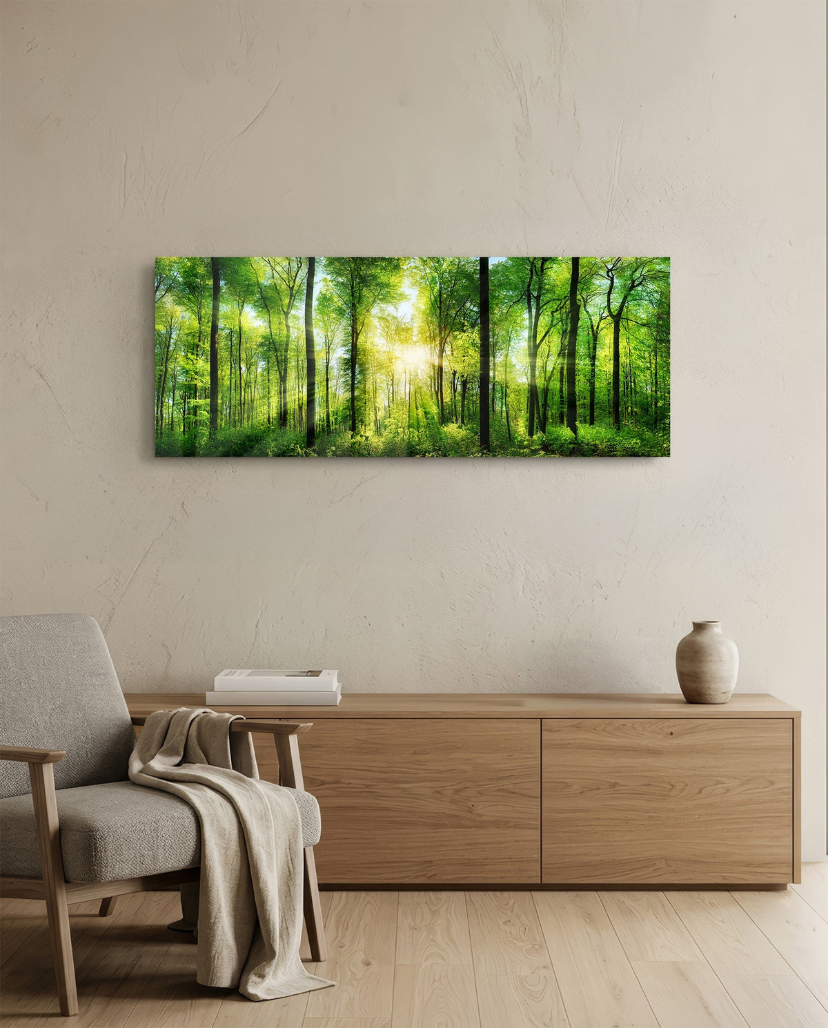 Green beech forest sunburst panoramic glass wall art above a light wood sideboard beside a gray armchair