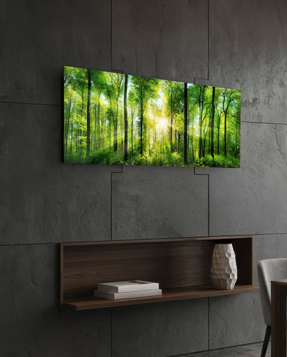 Green beech forest sunburst panoramic glass wall art above a floating wood shelf on a dark stone wall