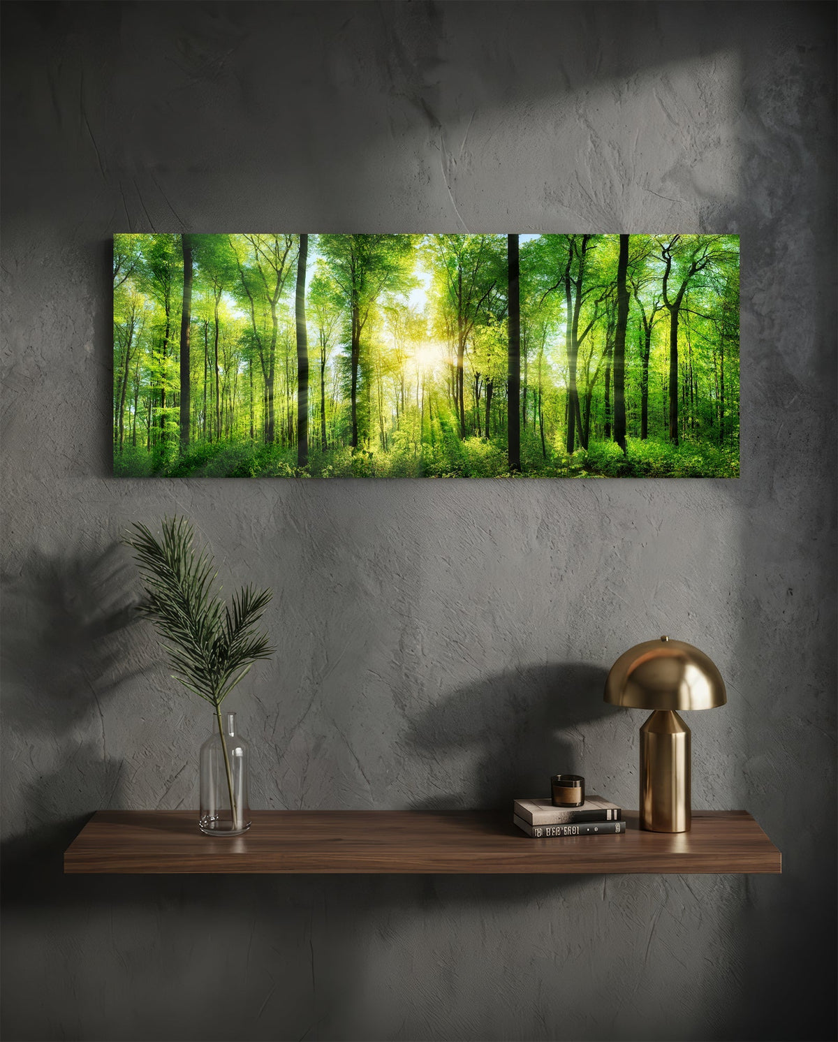 Green beech forest sunburst panoramic glass wall art above a wood shelf with a brass lamp on a dark wall