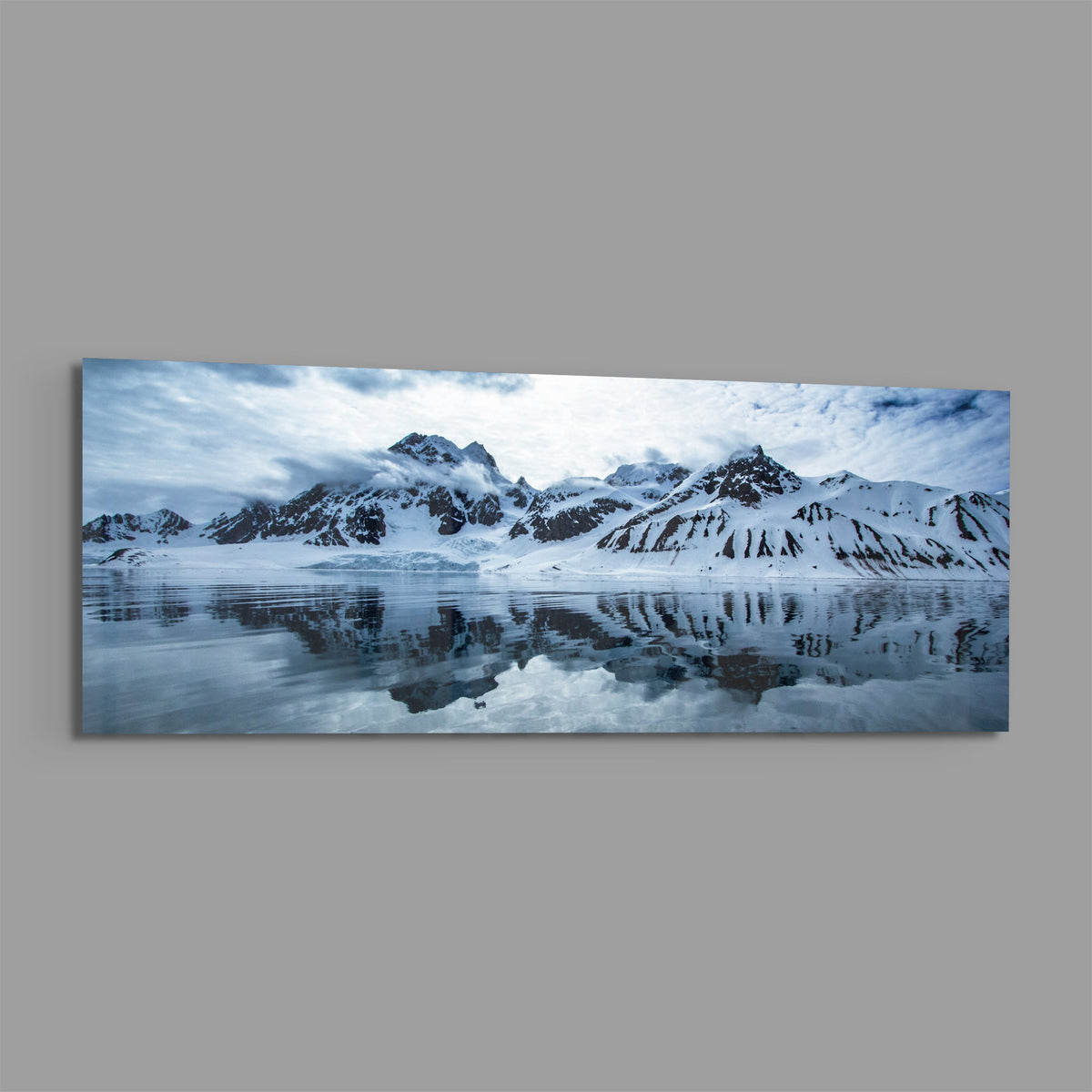Snowy mountains icy lake panoramic glass wall art on a plain gray wall