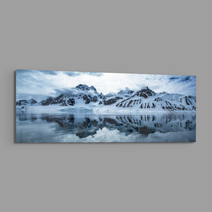 Snowy mountains icy lake panoramic glass wall art on a plain gray wall