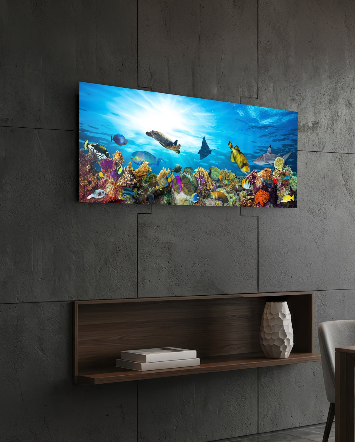 Coral reef sea turtle glass wall art above a dark wood wall shelf on a charcoal paneled wall
