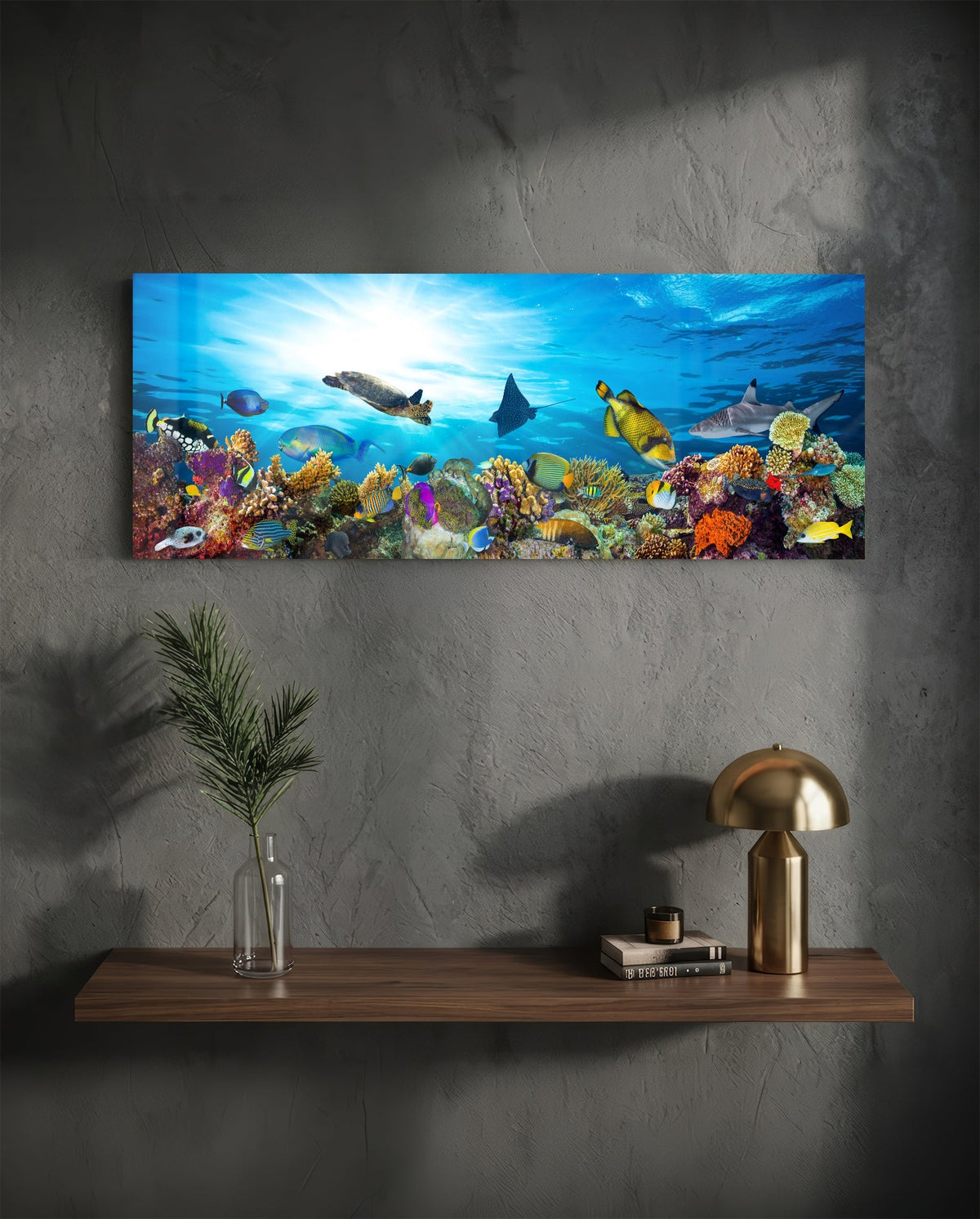 Coral reef sea turtle glass wall art above a floating walnut shelf with a brass lamp