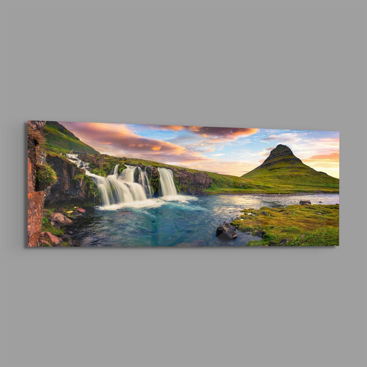 Waterfall and cone mountain panoramic glass wall art on a plain gray wall