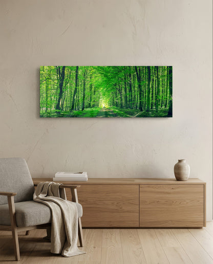 Green forest path glass wall art above an oak sideboard beside a wooden armchair with a throw