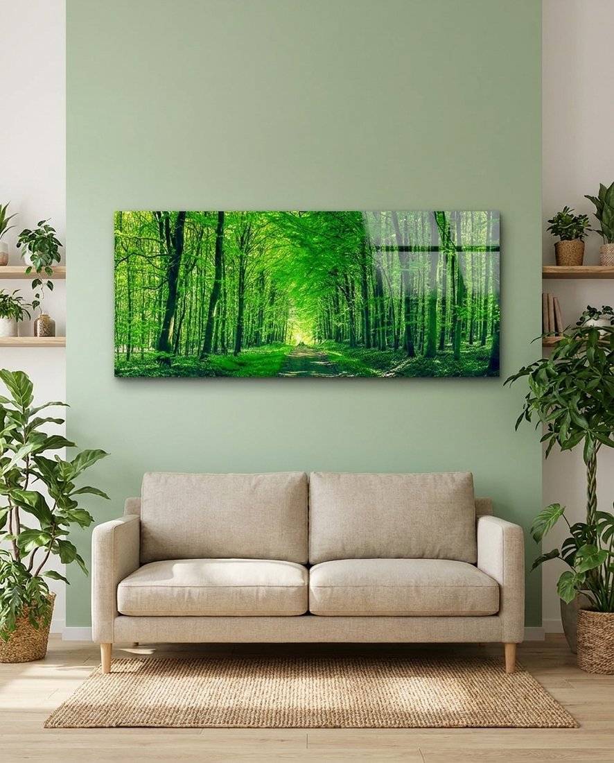Path into a tunnel of green trees and soft light, panoramic glass wall art on a sage green wall above a beige sofa