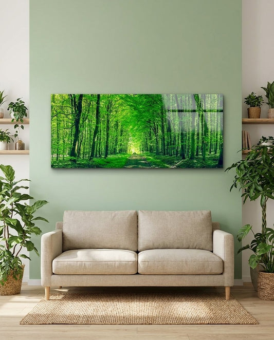 Path into a tunnel of green trees and soft light, panoramic glass wall art on a sage green wall above a beige sofa