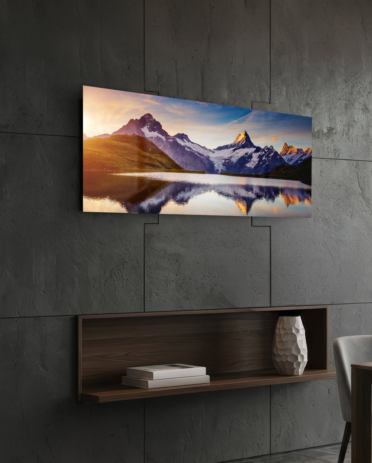 Sunrise alpine peaks lake panoramic glass wall art above a floating wood shelf on a dark stone wall