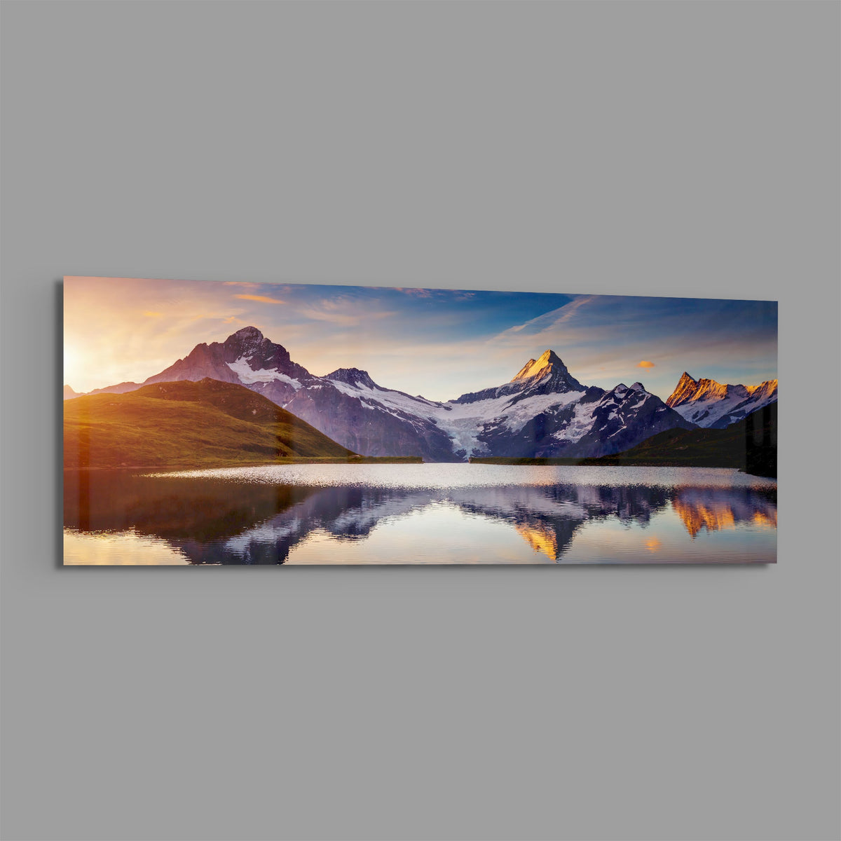 Sunrise alpine peaks lake panoramic glass wall art on a plain gray wall