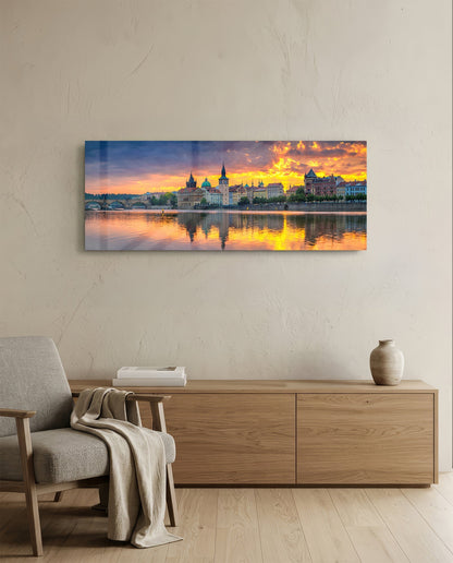 Prague riverside sunset panoramic glass wall art above a light wood sideboard and beige armchair
