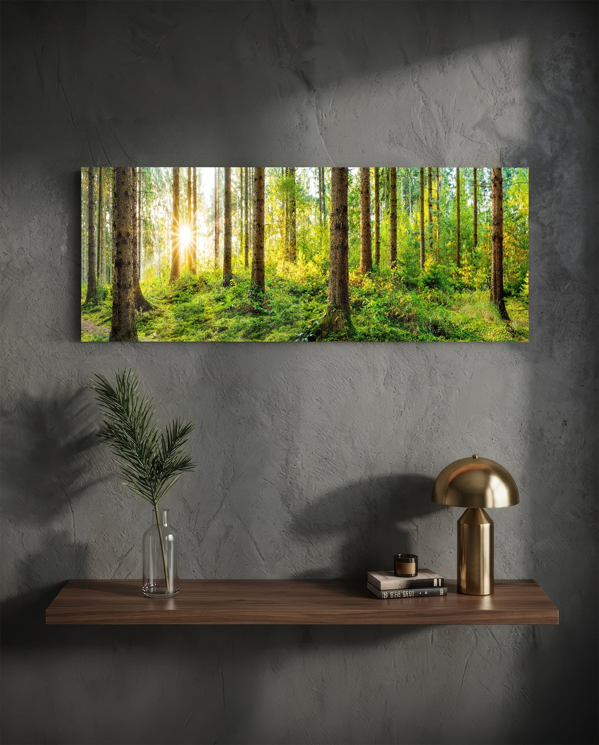 Sunlit mossy pine forest panoramic glass wall art above a wood shelf with a brass lamp on a dark wall