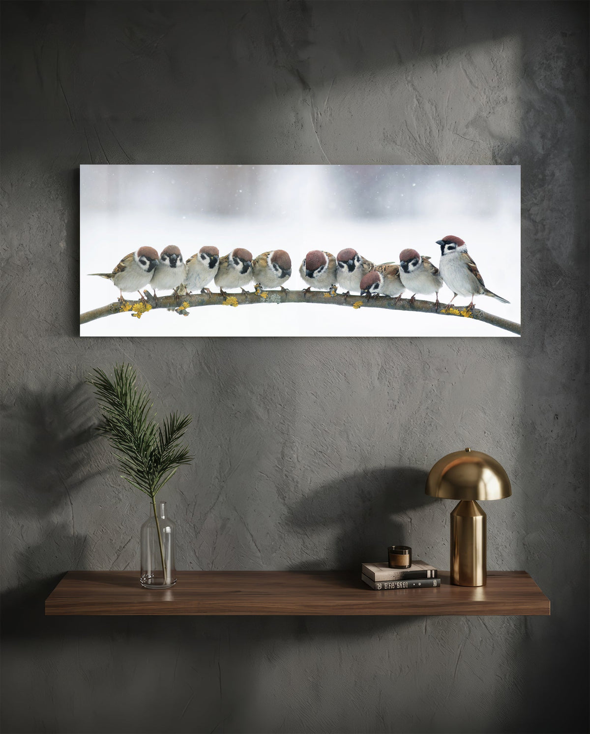 Sparrow flock glass wall art on a dark plaster wall above a floating shelf with a brass lamp