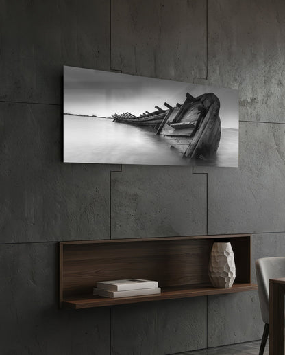 Black and white shipwreck glass wall art above a dark wood wall shelf on a charcoal paneled wall