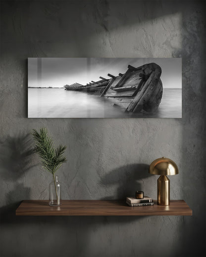 Black and white shipwreck glass wall art above a floating walnut shelf with a brass lamp