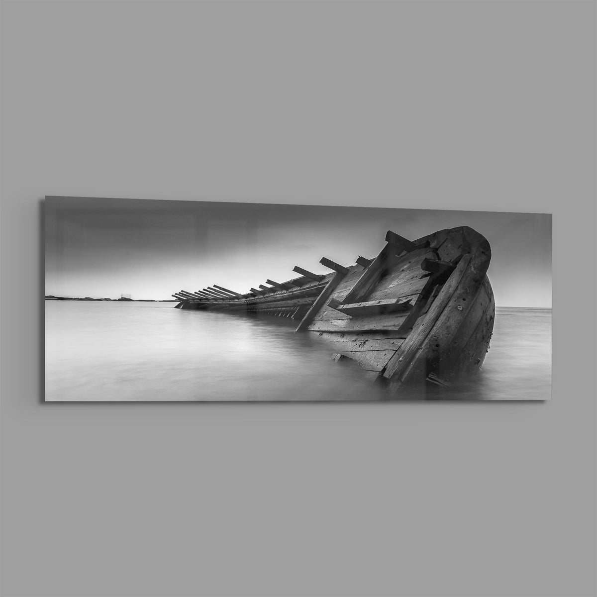Black and white shipwreck panoramic glass print angled on a gray background