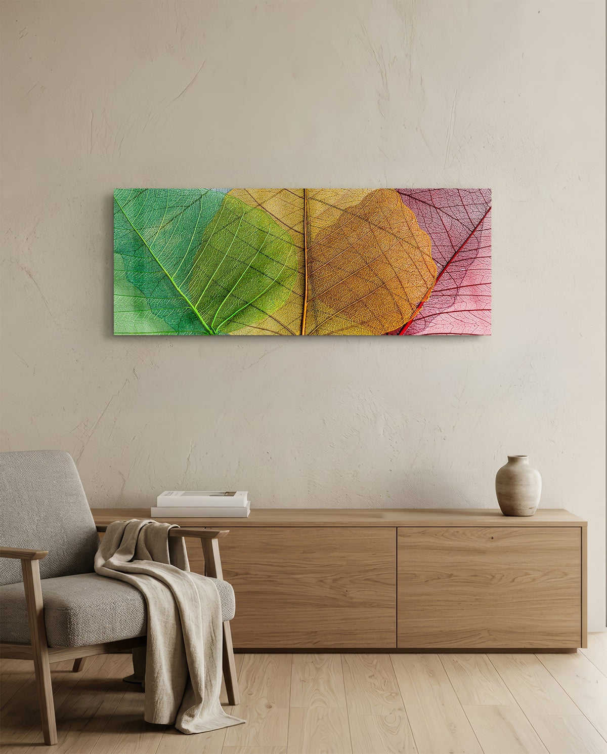 Green to pink veined leaves glass wall art above an oak sideboard beside a wooden armchair with a throw