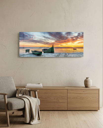 Fishing boats at sunset beach glass wall art above a light oak sideboard beside a cream armchair