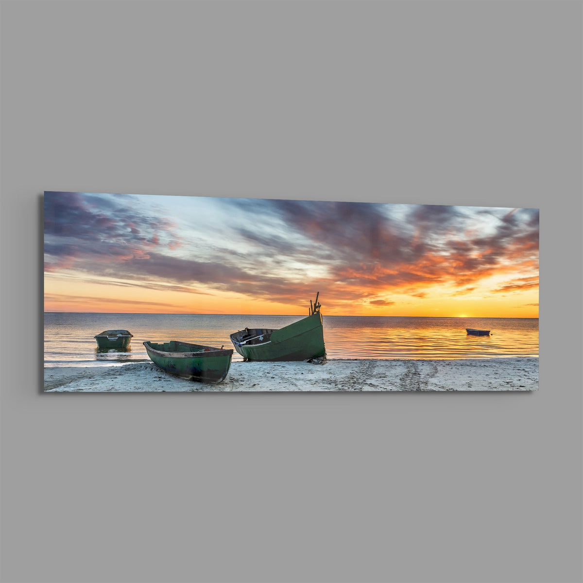 Fishing boats at sunset beach panoramic glass print angled on a gray background