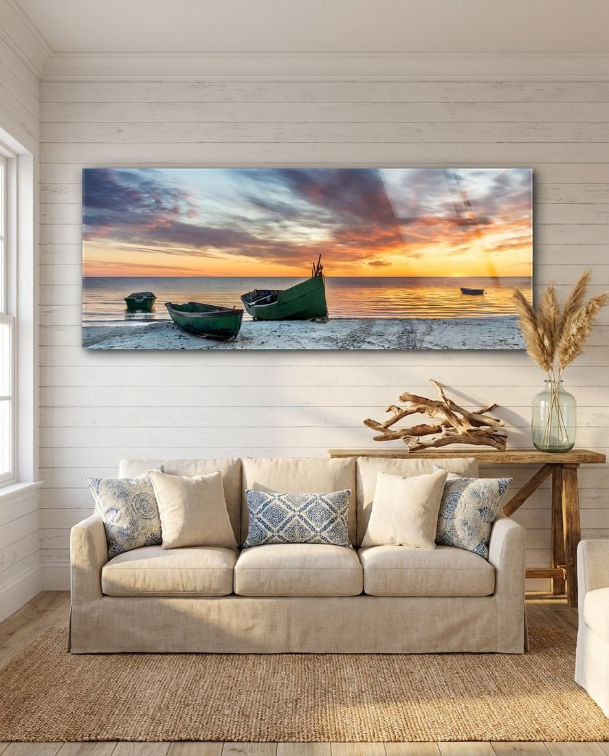 Fishing boats at sunset beach panoramic glass wall art above a cream sofa on a white shiplap wall