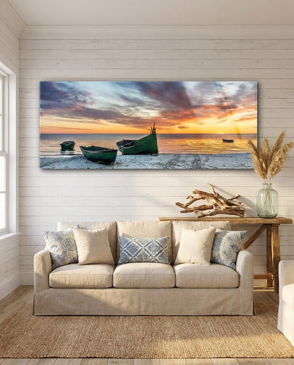 Fishing boats at sunset beach panoramic glass wall art above a cream sofa on a white shiplap wall