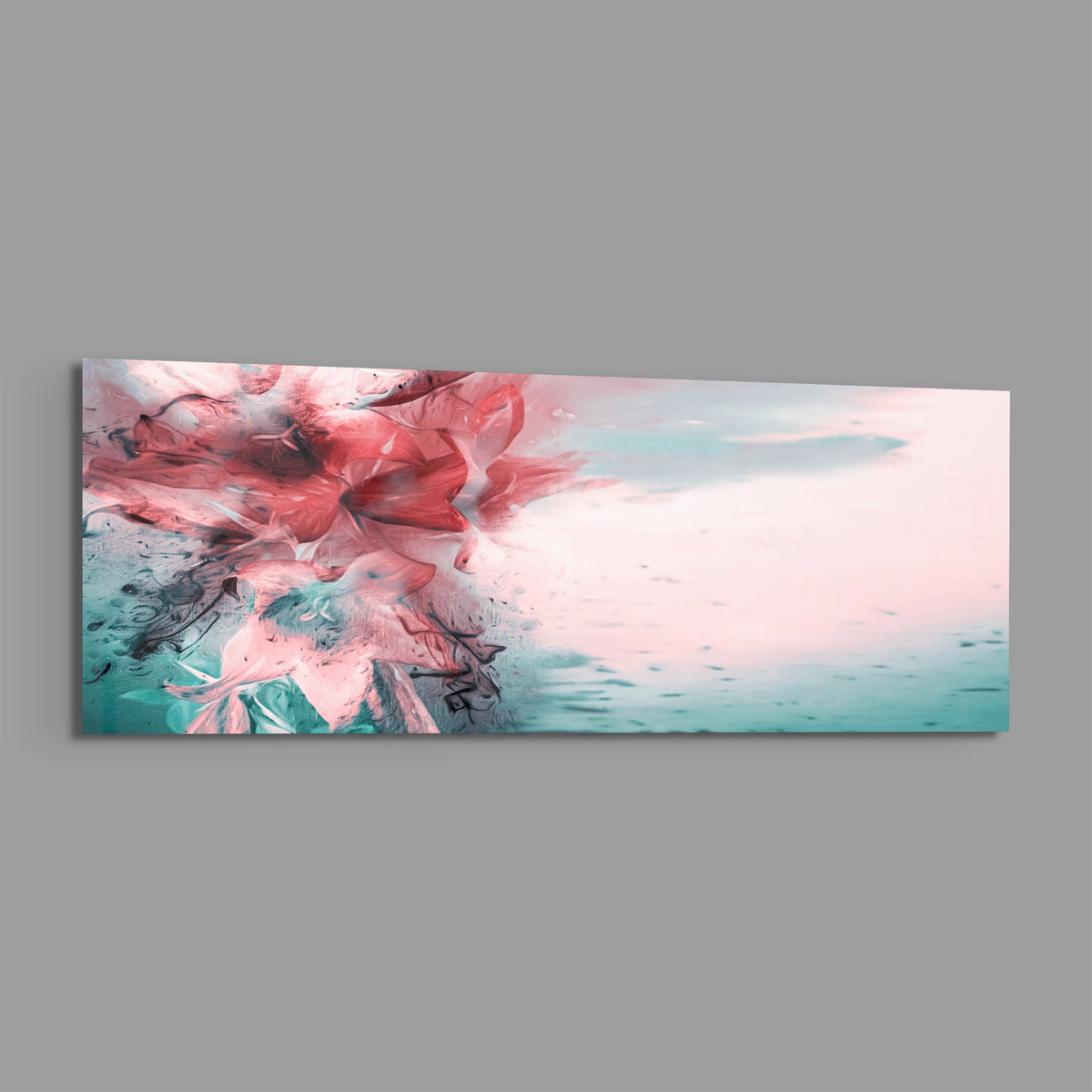Coral and teal ink burst abstract panoramic glass print angled on a gray background