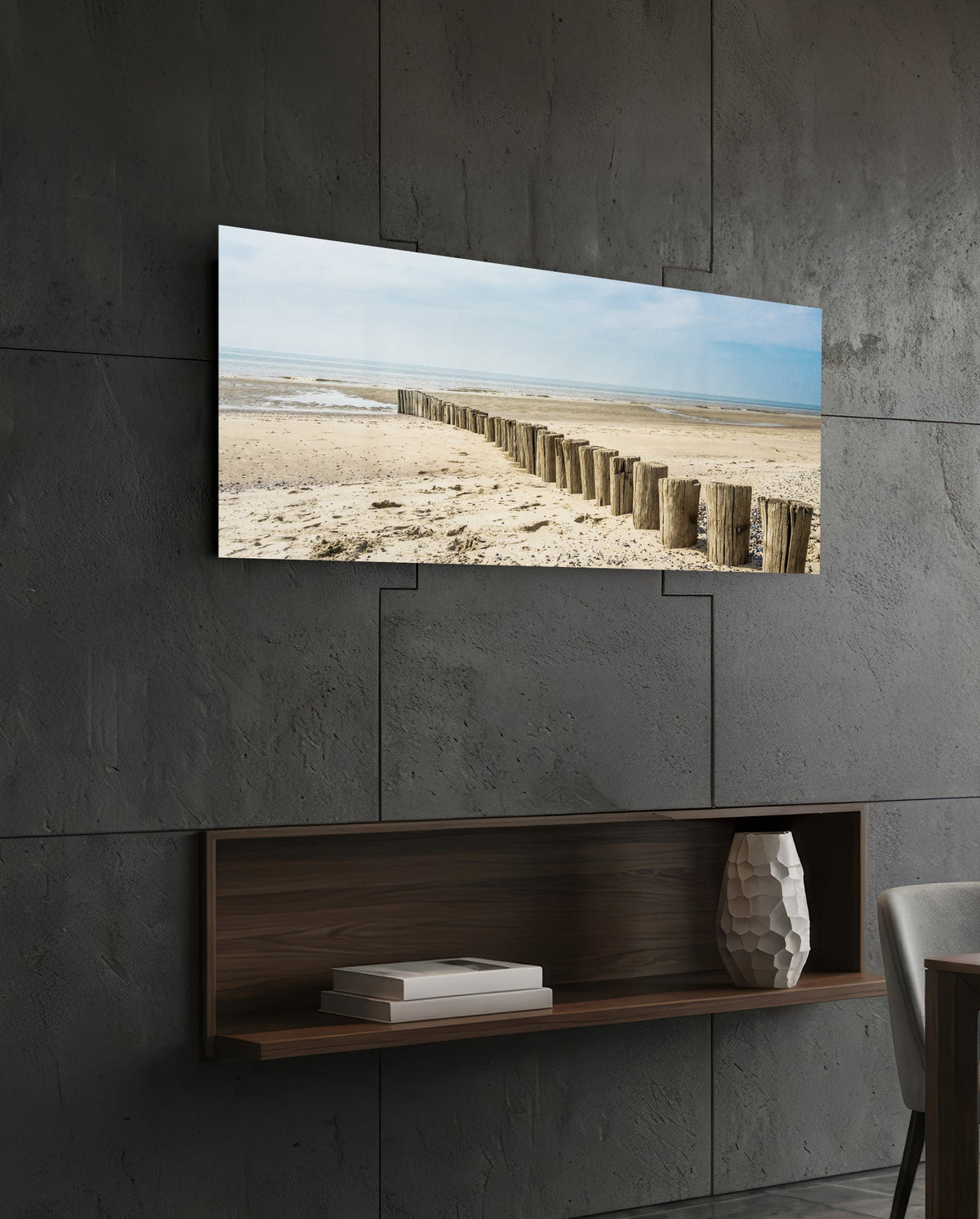 Weathered wood posts on the beach glass wall art above a dark wood wall shelf on a charcoal paneled wall