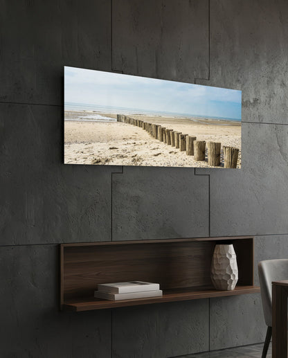 Weathered wood posts on the beach glass wall art above a dark wood wall shelf on a charcoal paneled wall